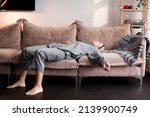 Small photo of Tired middle-aged woman collapsed on the sofa. Upset unhappy 40s female on the couch at home
