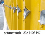 Small photo of Damaged industrial waste container. Indentation in a metal container with missing patches of paint. Missing paint on metal surface.