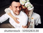 Small photo of Portrait of beautiful wedding couple, wife embosom her husband and whispering in his ear