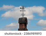 Weather vane against a blue sky