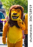 Small photo of TWINSBURG, OH, USA - AUGUST 8, 2015: A parade participant dressed in a lion costume walks in the Double Take Parade, part of the 40th annual Twins Day Festival.