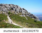 Mountain path leading to large rocks with across the Monchique mountains and countryside, Foia, Algarve, Portugal, Europe.