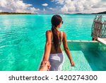 Follow me beach couple man holding girlfriend hand following woman to the swimming pool blue ocean vacation in Bora Bora, Tahiti ,French Polynesia.