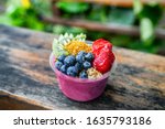 Small photo of Acai bowl healthy breakfast in to go plastic takeout bowl frozen yogurt smoothie with fresh fruits, berries, blueberries at Hawaii cafe. Foodie food snack.