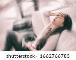 Small photo of Sick woman with headache feeling faint vertigo holding head in pain with fever and migraine. Blurry motion blur background.