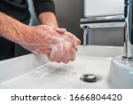 Corona virus travel prevention man showing hand hygiene washing hands with soap in hot water for coronavirus germs spreading protection.