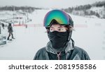 Small photo of Ski portrait. Iced up frozen ski goggles and ski helmet on man looking at camera with ski goggles icing up in freeze. Concept of Glaze ice, also called glazed frost snow when snowboarding or skiing