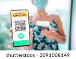 Small photo of Vaccine passport on mobile phone app screen woman tourist showing vaccination proof for COVID-19 at airport for vacation travel flight during coronavirus pandemic.