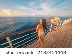 Cruise ship fun happy travel tourist woman enjoying sunset on deck feeling free with open arm relaxing at scenic view of ocean.
