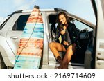 Young surfer woman in her car getting ready to surf