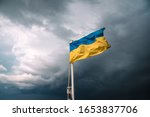 Ukrainian flag in the wind. Blue Yellow flag Against the background of a stormy sky