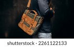 Small photo of Man with duffle bag on shoulder. leather and canvas bag
