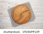 Empty pizza board and white tablecloth on wooden deck
