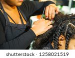 Close up african hairstylist braided hair of afro american female client in the barber salon. Black healthy hair culture and Style. Stylish therapy professional care concept. Selective focus