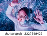 happy smiling woman with closed eyes and raised hands in white clothes and headphones dancing. Music lover. White dress code party, silent disco. Enjoy moment on shiny background. Selective focus
