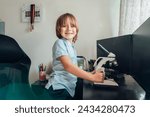Small photo of Portrait of inspired Caucasian boy using a microscope at home at his study place. Child curiosity, thirst for knowledge, home learning experience, home remote education concepts. Selective focus.