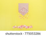 Small photo of Multicolor sweets sugar candy hearts pour forth of craft paper envelope on bright yellow background . Valentine day. love concept. Gift, message for lover. Space for text. Selective focus