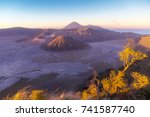 Small photo of Bromo Tengger Semeru National park when sunrise in the morning. The sky turn in to purple with high velocity wind blows aflutter grass in foreground.