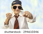 Funny elderly woman wearing cap and eyeglasses in a fight pose. Selective focus.