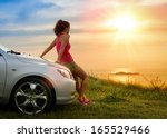 Female driver enjoying freedom and beautiful sunshine over the sea after driving to coast in summer vacation travel. Woman relaxing and taking a break to enjoy the scenery.