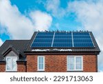 Small photo of Solar panels on the roof of an English new home. Numerous pigeons have chosen this sustainable house to sunbathe on a winter day.