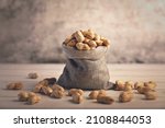 Pile of fresh organic Peanuts in jute bag	

