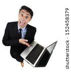 Small photo of Persuasive garrulous businessman pointing to his computer with his hand as he explains and cajoles trying to win the argument, high angle humorous isolated on white