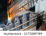 The abstract scene of plastic processing of PET bottles in the drinking water factory. The hi-technology of plastic bottle manufacturing process.