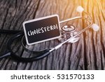 Medicine concept. Blackboard with word menopause and cholesterol on wooden background