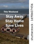Small photo of The words 'This Weekend Stay Away, Stay Home, Save Lives' written over a darkened photograph of a deserted beach and seaside pier to emphasise the message.