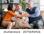 Small photo of happiness asian family candid of daughter hug grandparent mother farther senior elder cozy relax on sofa couch surprise visiting in living room at home,together hug cheerful asian family at home