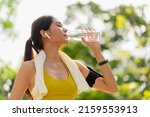 Young woman drinking water from ...