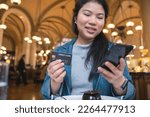 smiling asian female hand hold credit card sit relax casual at restaurant ,asian female hand hold credit card cashless lifestyle ideas concept,Asia woman show plastic credit card in restaurant