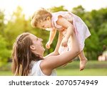 young mother lifting up her... | Shutterstock . vector #2070574949