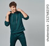 Small photo of Handsome man wear of green set of track suit isolated on gray background