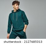 Small photo of Handsome man wear of green set of track suit isolated on grayl background